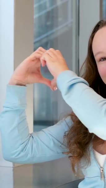 Czuła Piękna Dziewczyna Sprawia Serce Rękami Uśmiecha Się Siedzi Przy — Wideo stockowe