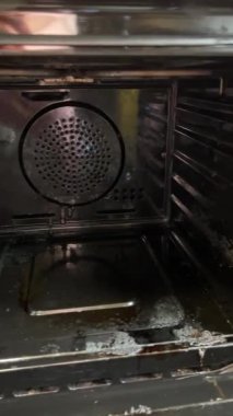 Mutfakta yemek pişirdikten sonra lastik eldiven giyen kadın fırını temizliyor. Fırın rafını önce ve sonra temizliyorum. Yüksek kalite 