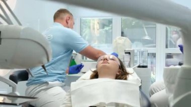 Erkek dişçi klinikte dişlerini tedavi ediyor. Yüksek kalite 4k görüntü