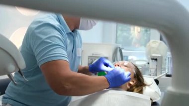 Erkek dişçi klinikte dişlerini tedavi ediyor. Yüksek kalite 4k görüntü