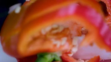 Yakın plan taze organik kırmızı dolma biber, yeşil kuyruklu, siyah arka plandaki bir masaya su damlalarıyla kaplı. Yüksek kalite 4k görüntü