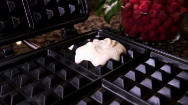 Çikolata sosuyla süslenmiş ahududu tabağıyla waffle ve beyaz arka planda izole edilmiş taze böğürtlen.