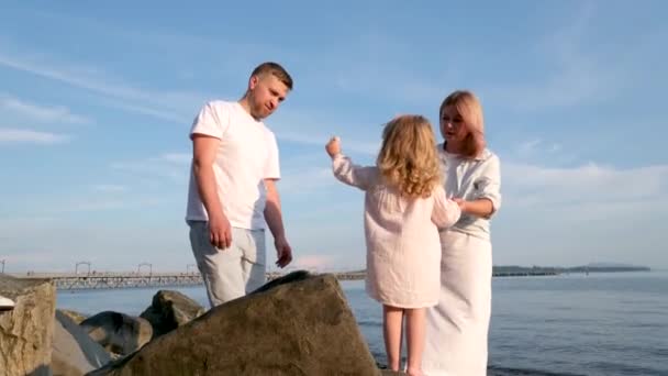 Junge Glückliche Familie Mit Dem Kind Bei Sonnenuntergang Wasser Schauen — Stockvideo