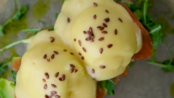 エッグベネディクトトーストイギリスのマフィン ポーチエッグ おいしいバターホランダースソース 高品質の写真 — ストック動画