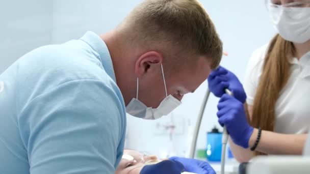 Manlig Tandläkare Som Behandlar Tänder Till Ung Kvinna Patient Kliniken — Stockvideo