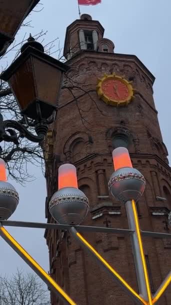 ハヌカ ダグナッツを スローモーションで粉砂糖で振りかける ハヌカは ウクライナのヴィニッツァ市の冬の都市時計塔の背景に光を当てる — ストック動画
