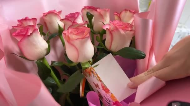 誕生日の女の子のためのパッケージの美しいピンクのバラのためのカードは テキストのお祝いの誕生日7つの明るい花のためのノートの空のスペースでカードを開きます ギフトありがとうございました — ストック動画