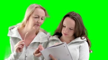 Anne ve kızı ödev yapıyor, gözlüklü kadın, bir şeyler yazmaya çalışan genç kız, gülüyor, gülümsüyor, hoş vakit geçiriyor, çocuğa anlatıyor, sürpriz, elle işaret ediyor.
