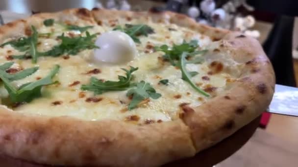アルグラとモッツァレラで引き裂かれた4つのチーズピザは チーズのクローズアップおいしいピザは木製のボードではありません ブラックバック クローズアップ イタリア料理 — ストック動画