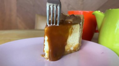Karamelli cheesecake yiyorum. Çatalla karamel peynirli kek yiyorum. Yüksek kalite 4k görüntü
