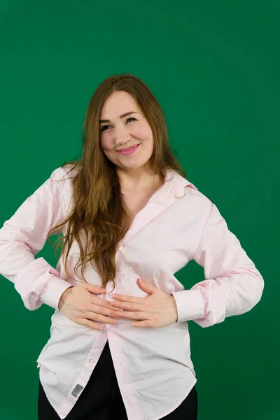 Açık yeşil arka planda dar tişörtlü şişman bir adam, yakın plan. Yüksek kalite fotoğraf