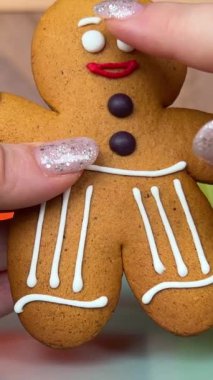 Noel için zencefilli adam hediyesi. Lezzetli kurabiyeler paketleme dansından güzel oyuncak lezzetindeki kadın ellerinden alınır. Parlak Noel manikürlü hediye Yami. Kışın sembolü Yeni Yıl
