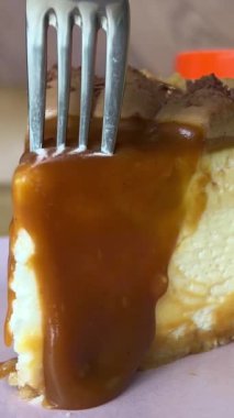 Karamelli cheesecake yiyorum. Çatalla karamel peynirli kek yiyorum. Yüksek kalite 4k görüntü