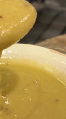 Kepçenin süper yakın plan görüntüsü balkabağı çorbası püresini yavaş çekimde Keema Curry, kısa video klibi ile karıştırıyor. Yüksek kalite