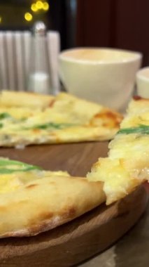 Peynirli ve roka soslu pizza, bir el taze pişmiş lezzetli bir parça çeker. Taze pizza, bir dilim pizza ve süper esnek peynir. Yüksek kalite 4k görüntü