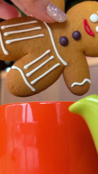 与姜饼人共度佳节的圣诞佳肴 将一只手把饼干蘸到一杯咖啡 水果蛋糕和小面包饼干中 以及驯鹿饰物的中心部分闪烁着光芒 — 图库视频影像