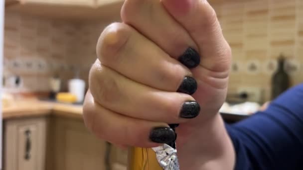 在家里开香槟一个有黑色指甲的胖女人的手在厨房 普通公寓 真正的人们在家里和家人一起庆祝的特写瓶子颈打开了香槟酒瓶塞 — 图库视频影像