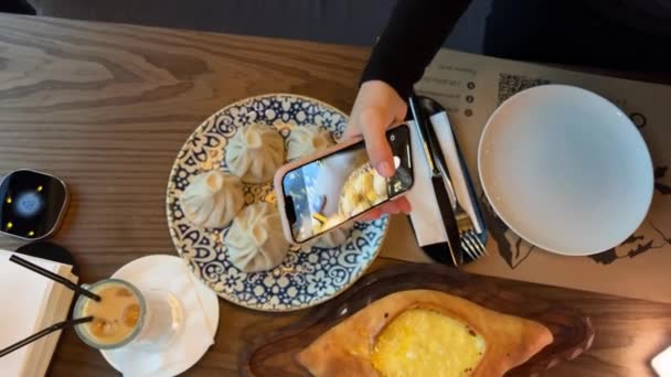 Eine Mädchenhand Fotografiert Essen Einem Georgischen Restaurant Chatschapuri Chinkali Wasser — Stockvideo