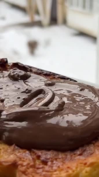 Espalhando Chocolate Sobre Uma Torta Contra Pano Fundo Uma Janela — Vídeo de Stock