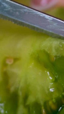 Genç bir kadının domates kesmesi.