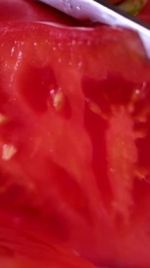 Güzel, iştah açıcı kırmızı bir domates dilimliyorum. Yüksek kalite 4k görüntü