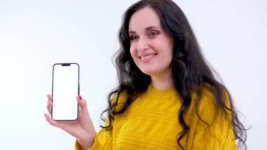 Cep telefonunu işaret eden genç bir kadın. Wow Lady sosyal medya için akıllı telefondan, online yayınlardan, haberlerden ve internetten, sürpriz surattan çok etkilendi. Stüdyo çekimi beyazda izole edildi
