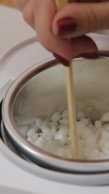 Kadın zanaatkârların cam kavanozda el yapımı mumları karıştırıp mum yapımında kullanılan malzemeleri kaynayan su kabına karıştırıp mum yapımında kullandıkları yakın çekim. Doğal mum yapma süreci.