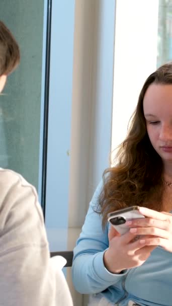 소년과 소녀가 테이블에 전화에 청소년의 와이파이 파란색 색상이있을 자신의 스마트 — 비디오