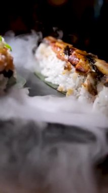 Lezzetli bir restoranda Asya yemeği suşisi tabağında kuru buz dekorasyonu restoranı taştan tabakta lezzetli ton balığı seti ve uzay metni reklamının her yerinde akan beyaz dumanla servis ediliyor.