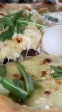 Dört peynirli pizza roka ve peynirli mozzarella peynirle koparılmış peyniri yakın plan fırında pişirilmiş İtalyan pizzası bir kafede ahşap bir masada. Yakın plan. Arkaplan.