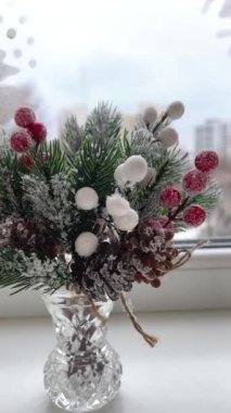 Şenlik süslemeleri. Tasarımcı-dekoratör işi. Noel arifesinde. Noel süsü. Donmuş kırmızı böğürtlenli yapay çam dalı. 4 bin. Yüksek kalite 4k görüntü