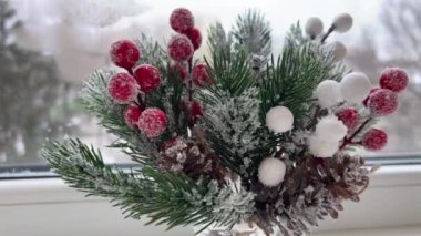 Şenlik süslemeleri. Tasarımcı-dekoratör işi. Noel arifesinde. Noel süsü. Donmuş kırmızı böğürtlenli yapay çam dalı. 4 bin. Yüksek kalite 4k görüntü