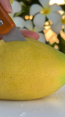 Olgun, sulu, tatlı mangoyu tek parça halinde kes ve ahşap arka planda yarım dönüş yap. Yaz tropik meyveleri, sağlıklı yiyecekler, mango suyu, organik mango. 4K görüntüler. Yüksek kalite 
