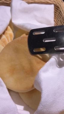 Açık büfede Pita ekmeği. Cihazı kullanarak al. Beyaz peçeteye küçük bir pide ekmeği. Enfes güzel bir sunum, seçim