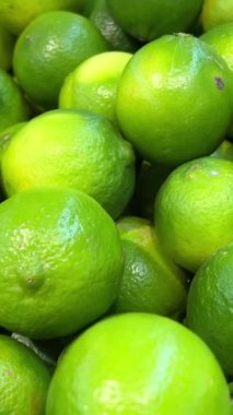 Mango, limon ve domatesli renkli meyve ve sebze standı. Sulu görünümlü sarı, yeşil ve kırmızı meyveler tezgahta satılıyor. Doğal sağlıklı yiyecekler. Yüksek kalite 4k görüntü