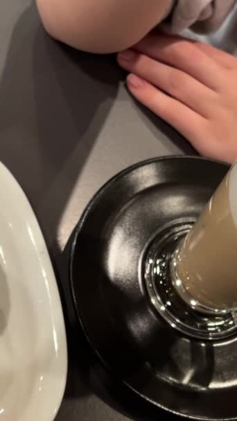 特写镜头 一只手在搅拌一杯背景模糊的咖啡 高质量的4K镜头 — 图库视频影像