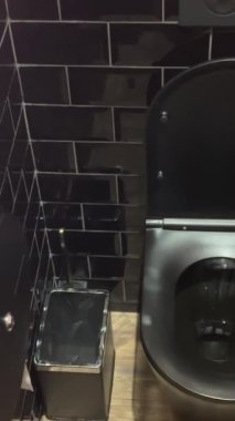 Kabinin içindeki modern umumi tuvalet temiz tuvalet, duvara monte edilmiş tuvalet kağıdı, çöp öğütücü dezenfektanı. Banyo içinde beyaz seramik klozet. Hijyen konsepti. - Evet. Yüksek kalite