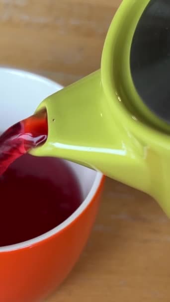 Yeşil Çaydanlıktan Kırmızı Turuncu Bir Fincana Ahşap Bir Masada Kırmızı — Stok video