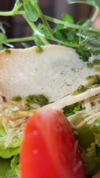 在餐馆里 凯撒沙拉可罗顿小绿豆西红柿放在白盘红桌布上 鹌鹑蛋生菜和酱汁在餐馆里吃餐具 叉子刀 — 图库视频影像