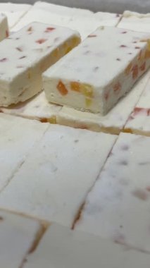 Mağazanın vitrininde jöle parçaları olan marşmelovlar self-servis beyaz tatlı parçaları toplar ahşap bir tahtadan fındık satın alır. Yüksek kalite 4k görüntü