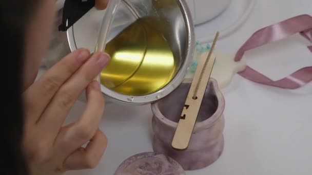 自宅でろうそくを作る女性 パンからシリコンモールドに黄色い液体ワックスを注ぐ女性の手の近く 高品質のカットオフ獣医キャンドルアロマキャンドル — ストック動画
