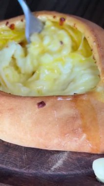 Lokantada Adjarian Khachapuri 'nin malzemelerini çatalla karıştırıyorum. Peynirli ve yumurtalı turta. Lezzetli Gürcü mutfağı. Yüksek kalite 4k görüntü