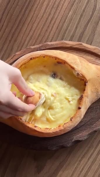 アジャリアン ハチャプリの成分をフォークで混ぜた女性手 チーズと卵黄 グルジア料理の伝統的な料理を詰めたオープンパンです クローズアップ 高品質で — ストック動画