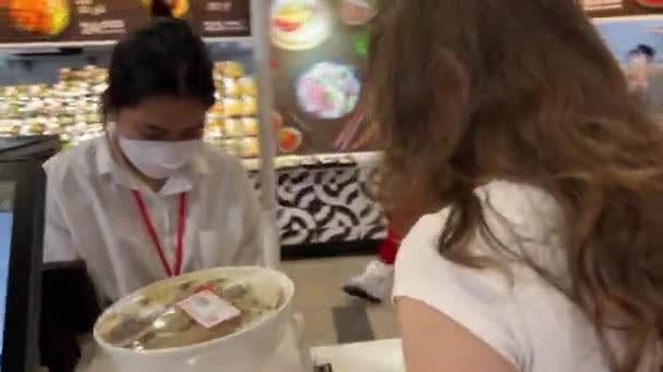 店にいるリアルな人々 アジアのサルパーソンを持つヨーロッパの女の子は 翻訳の難しさを互いに理解していない翻訳を買います ホーチミン市の営業担当者に説明する 2024 — ストック動画