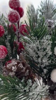 Şenlik süslemeleri. Tasarımcı-dekoratör işi. Noel arifesinde. Noel süsü. Donmuş kırmızı böğürtlenli yapay çam dalı. 4 bin. Yüksek kalite 4k görüntü
