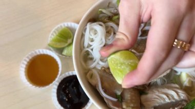Genç bir kız Vietnam 'daki alışveriş merkezinde tavuk ile nefis pho bo çorbası içiyor. Ho Chi Minh City' de ucuz yemekler pişiriyor. Saygon