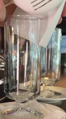 Barmen kadın içki içmek için büyük buz küplerini bardağa dolduruyor. Buzu bardağa at.