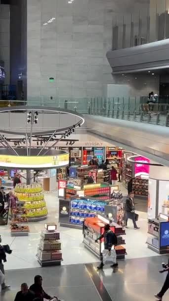 卡塔尔多哈哈马德国际机场候机厅夜间向游客展示卡塔尔免税品 乘客带着行李在机场路上行走 多哈机场02 2024 — 图库视频影像