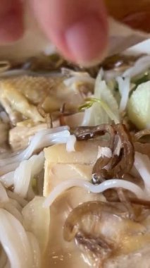 Genç bir kız Vietnam 'daki alışveriş merkezinde tavuk ile nefis pho bo çorbası içiyor. Ho Chi Minh City' de ucuz yemekler pişiriyor. Saygon