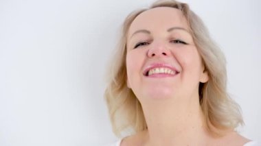 Hoş hayaller kuran hoş bir kadın. Düşünceli, yuvarlanan sesler uzanıyor. Kafası beyaz, gülümseyen, yüzünde bir gülümseme.